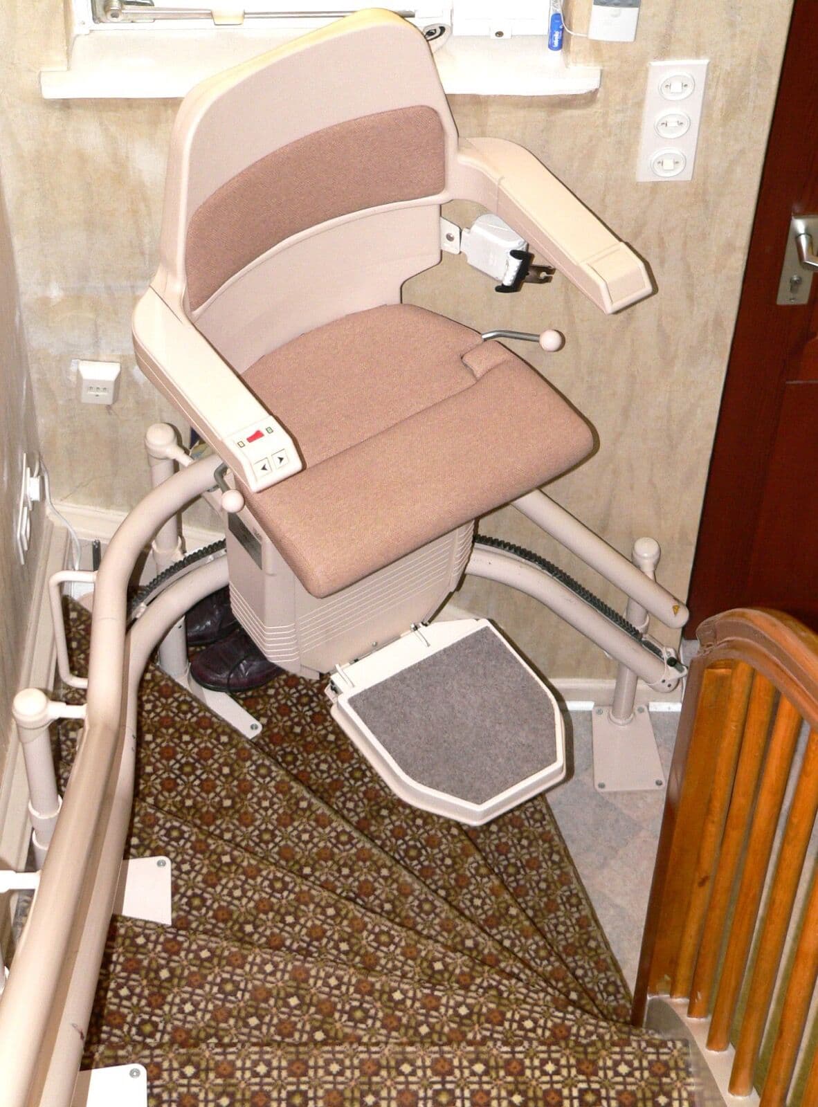 A curved stairlift on a winding staircase with a custom-bent rail following the turns