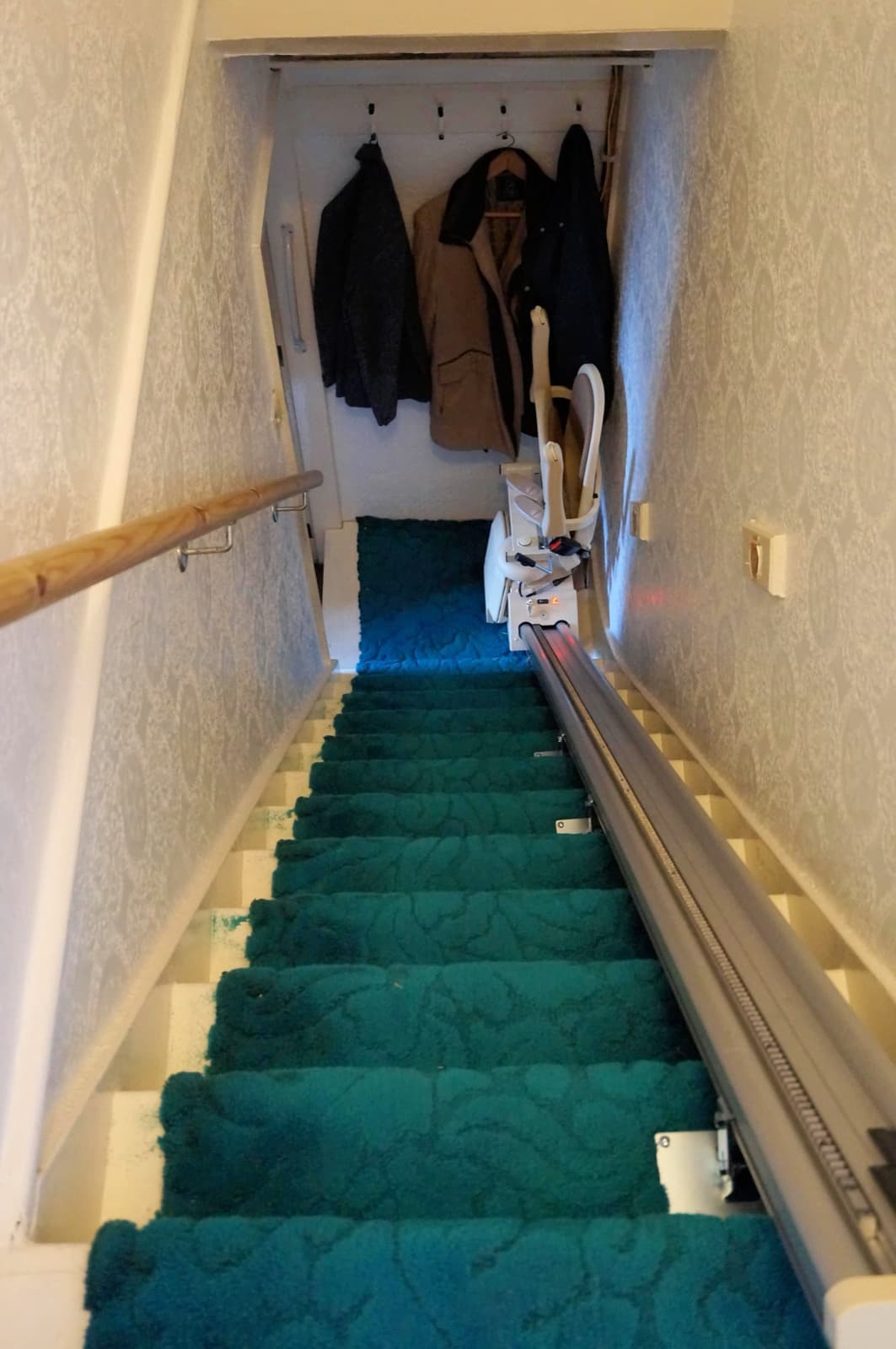 A slim straight stairlift rail fitted in a narrow home staircase, seen from the top