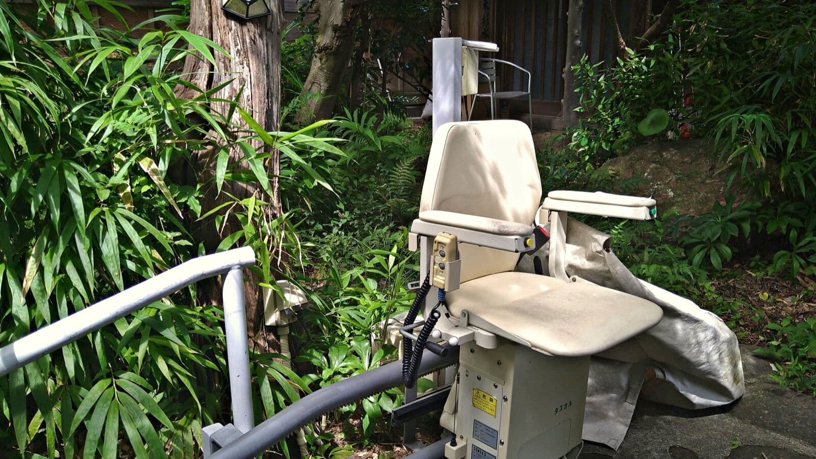 An outdoor stairlift installed on garden steps beside a house